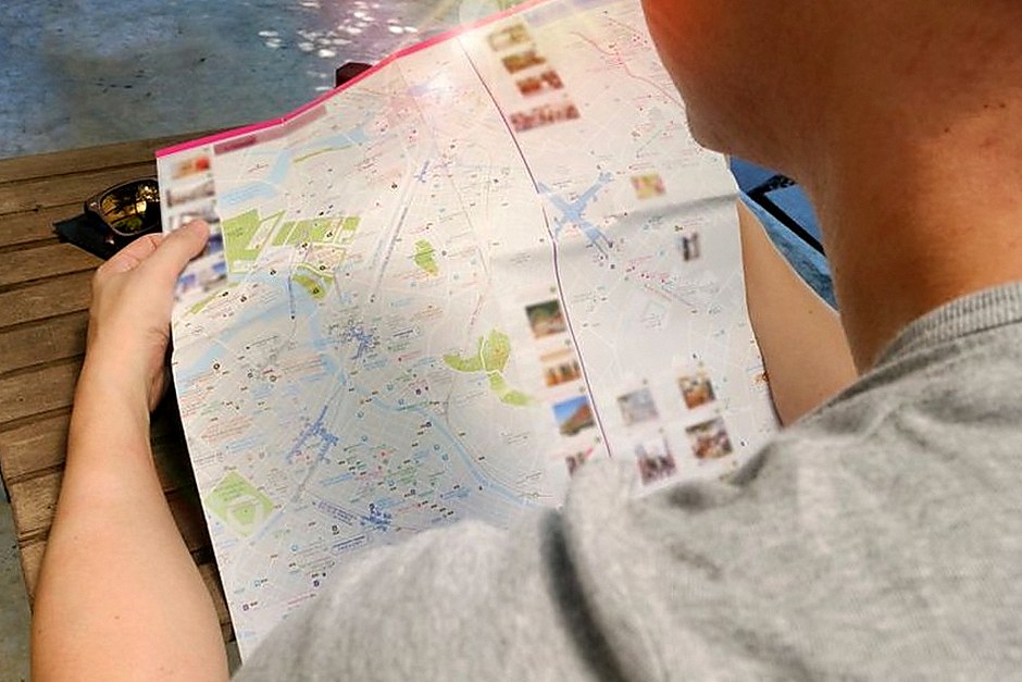Person studying a paper city map